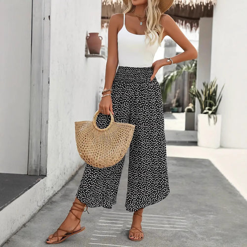 Pantalon palazzo noir à pois blancs pour femme porté avec un top blanc